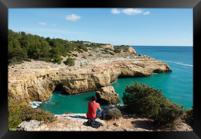 Man looking at a wild hidden secret beach with amazing turquoise water in Algarve, Portugal Framed Print by Luis Pina