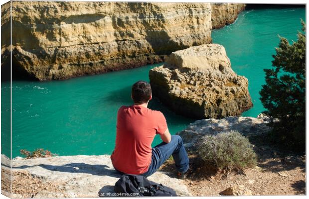 Man looking at a wild hidden secret beach with amazing turquoise water in Algarve, Portugal Canvas Print by Luis Pina