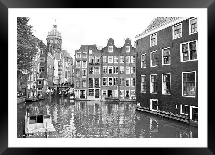A small boat in a body of water with a city of Amsterdam. Framed Mounted Print by M. J. Photography