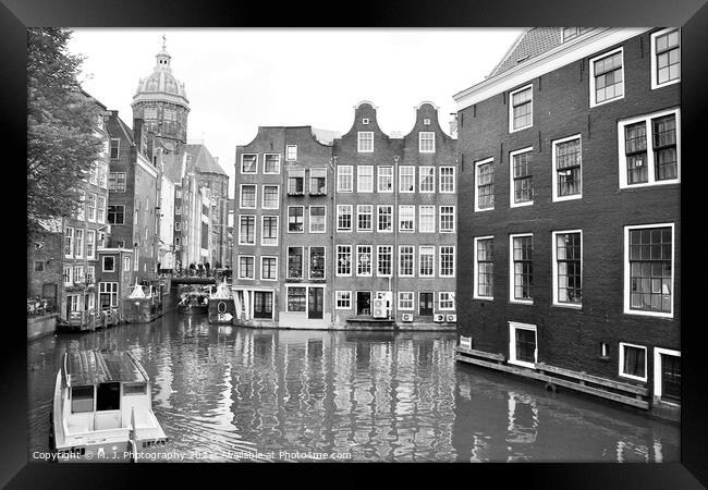 A small boat in a body of water with a city of Amsterdam. Framed Print by M. J. Photography