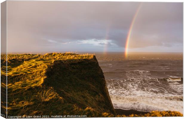 Rainbow and stormy sky at sunset. Sheringham, Norfolk, UK. Canvas Print by Liam Grant