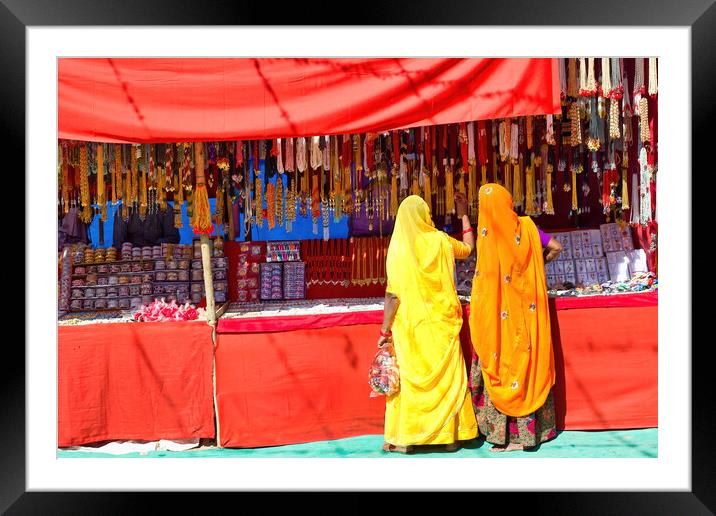 Couple of unidentified women in traditional hindu wear saree buying or shopping jewelery items in the commercial street of Pushkar fair in state of Rajasthan, India. Colorful Indian culture concept Framed Mounted Print by Arpan Bhatia