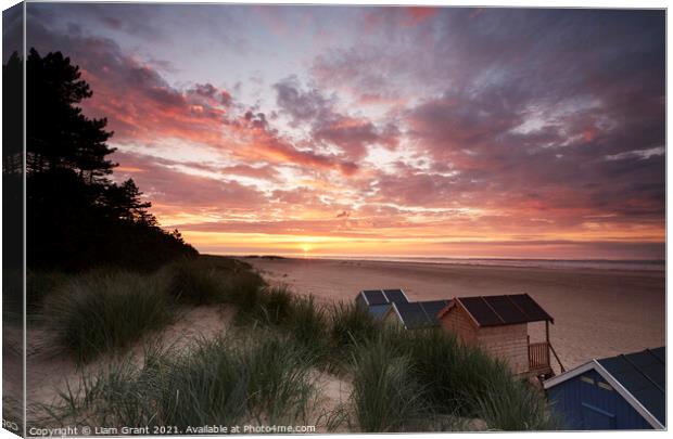Sunset, beach huts and dunes at Wells-next-the-sea. Norfolk, UK. Canvas Print by Liam Grant