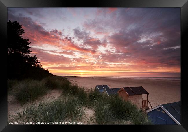 Sunset, beach huts and dunes at Wells-next-the-sea. Norfolk, UK. Framed Print by Liam Grant