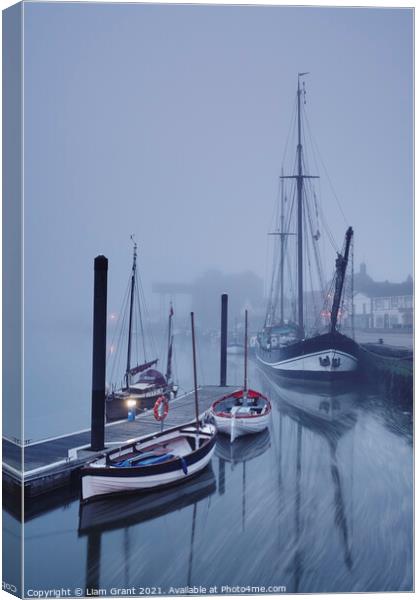 Boats moored in the harbour in fog at dawn. Wells-next-the-sea, Canvas Print by Liam Grant