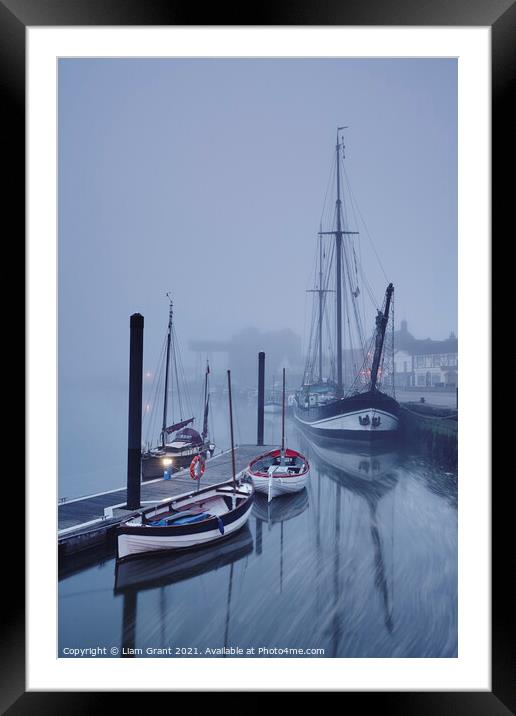 Boats moored in the harbour in fog at dawn. Wells-next-the-sea, Framed Mounted Print by Liam Grant