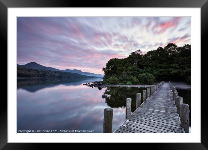 Jetty and reflections on the surface of Coniston Water at dawn. Framed Mounted Print by Liam Grant