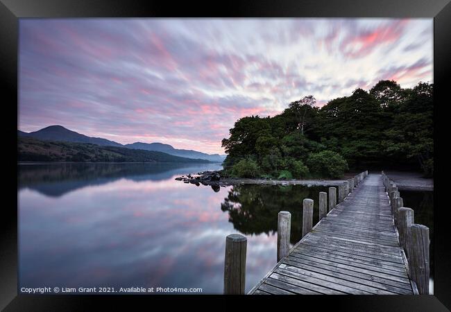 Jetty and reflections on the surface of Coniston Water at dawn. Framed Print by Liam Grant