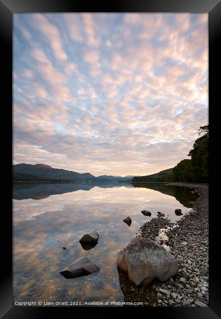 Reflections on the surface of Coniston Water at sunrise. Cumbria Framed Print by Liam Grant