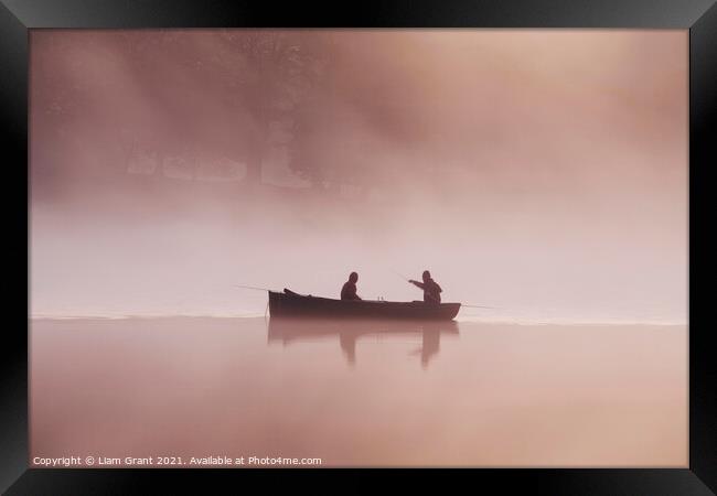 People fishing from a boat on a misty lake at dawn. Framed Print by Liam Grant