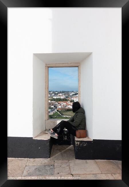 Woman girl traveler sit and looking through a white wall window Estremoz city and Alentejo landscape, in Portugal Framed Print by Luis Pina