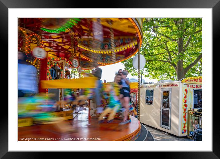 Fairground carousel ride blurred to show speed and movement with small child watching, London UK Framed Mounted Print by Dave Collins