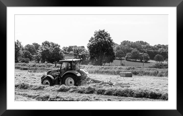 Tractor lining up the hey ready to bale in black and white Framed Mounted Print by Ollie Hully