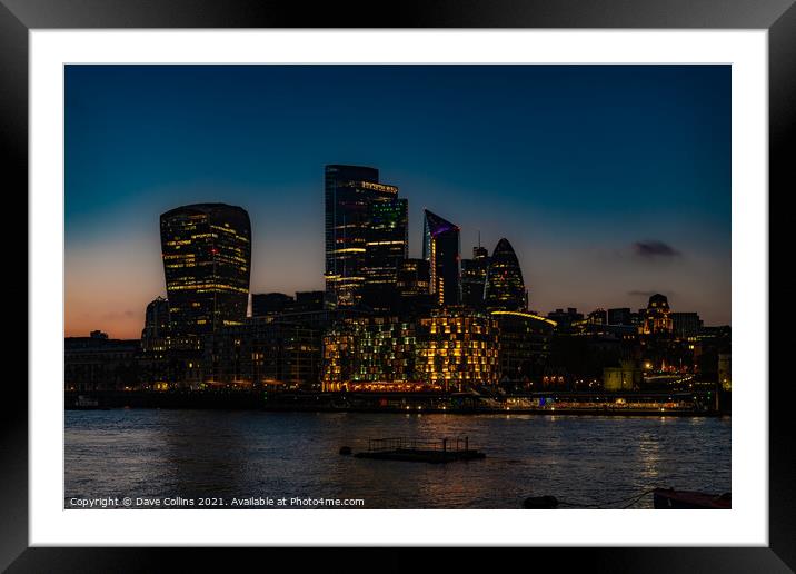 City of London Financial District buildings illuminated at dusk from the south bank walkway by Tower Bridge in London, UK Framed Mounted Print by Dave Collins