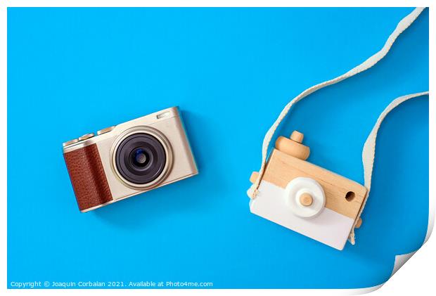 Two cameras, one modern and one old, compared one next to the ot Print by Joaquin Corbalan