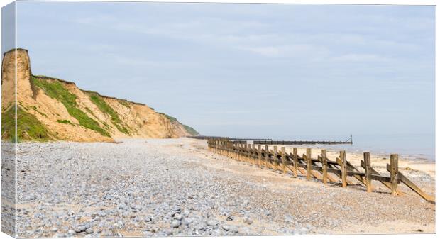 Pebbles and sea defences at West Runton beach Canvas Print by Jason Wells