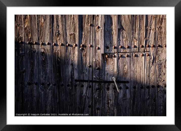 Old and decrepit wooden gate, half lit by the sun, in an unpopul Framed Mounted Print by Joaquin Corbalan