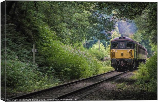 Heritage Diesel train framed by the trees Canvas Print by Richard Perks