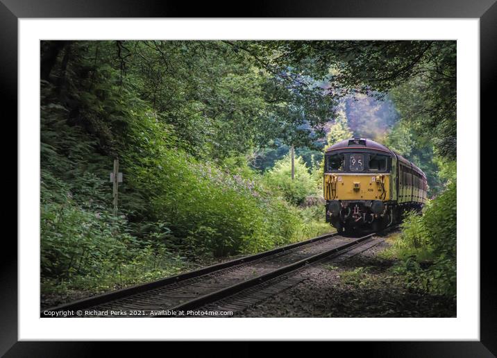 Heritage Diesel train framed by the trees Framed Mounted Print by Richard Perks