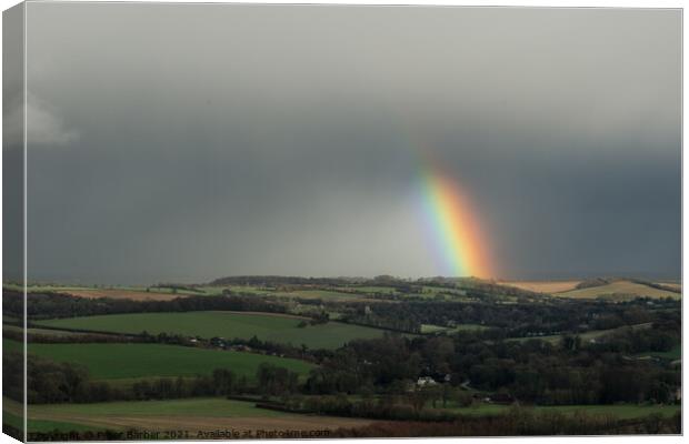 A rainbow over fields in the hampshire countryside Canvas Print by Peter Barber