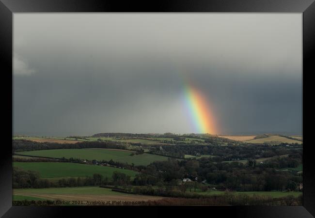 A rainbow over fields in the hampshire countryside Framed Print by Peter Barber