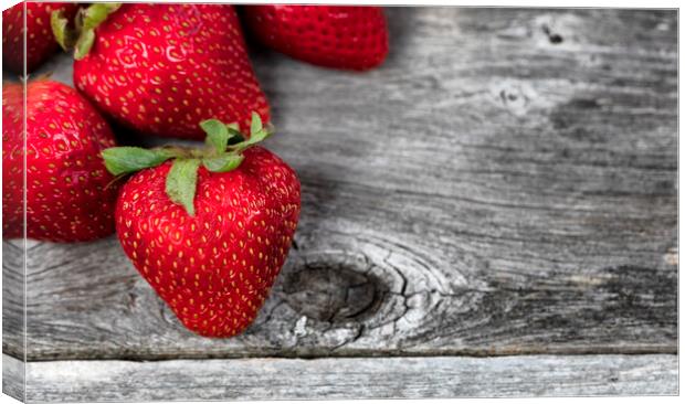 Close up of fresh strawberry fruit on rustic wood Canvas Print by Thomas Baker