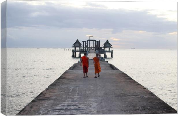 Thai monks on the bridge or Pier , which leads to the never finished and abandoned Thai temple right on the Gulf in Thailand in the province of Chonburi Canvas Print by Wilfried Strang