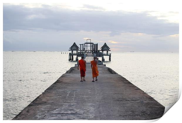 Thai monks on the bridge or Pier , which leads to the never finished and abandoned Thai temple right on the Gulf in Thailand in the province of Chonburi Print by Wilfried Strang
