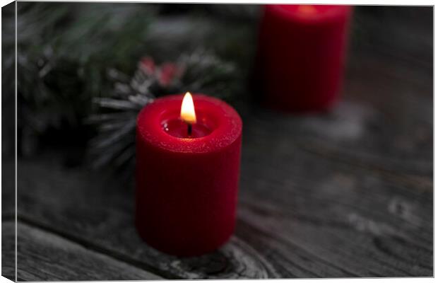 Close up of single red glowing candle with fir and wood dark bac Canvas Print by Thomas Baker