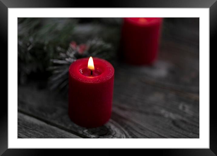 Close up of single red glowing candle with fir and wood dark bac Framed Mounted Print by Thomas Baker
