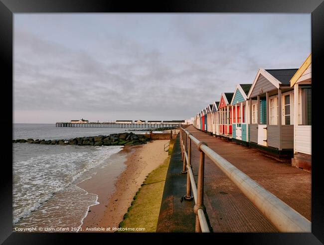 UK, Suffolk, Southwold pier and colourful beach huts at sunrise Framed Print by Liam Grant
