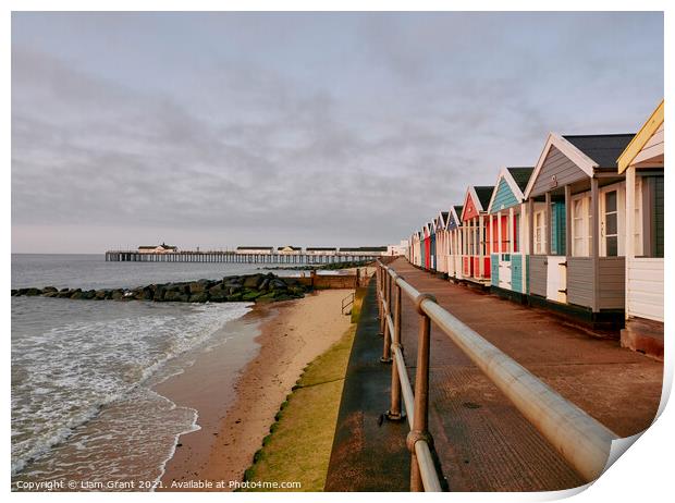 UK, Suffolk, Southwold pier and colourful beach huts at sunrise Print by Liam Grant