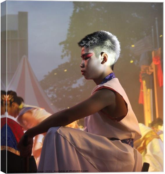 Chinese boy squats down on stage at a festival Canvas Print by Hanif Setiawan