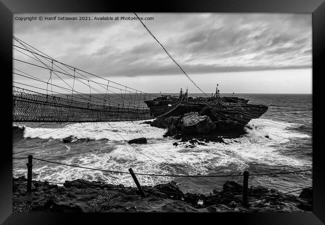 Swinging rope foot bridge to a rock island Framed Print by Hanif Setiawan