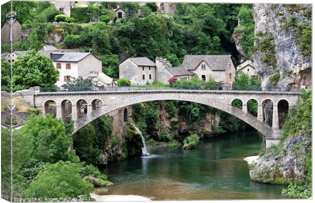 Idyllic Stone Village with Arched Bridge Canvas Print by Roger Mechan