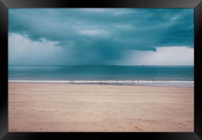Unsettled dark sky over the beach in Brittany Framed Print by Laurent Renault