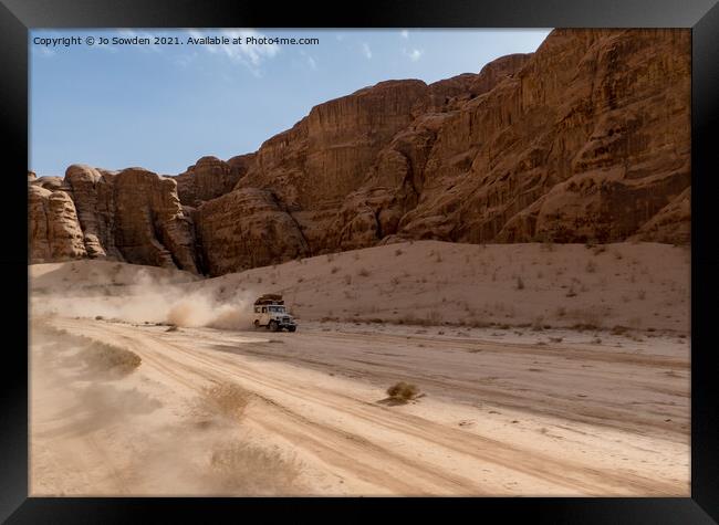 Jeep speeding through Wadi Rum, Jordan Framed Print by Jo Sowden