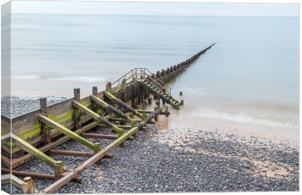 Wooden groyne stretching into the sea Canvas Print by Jason Wells