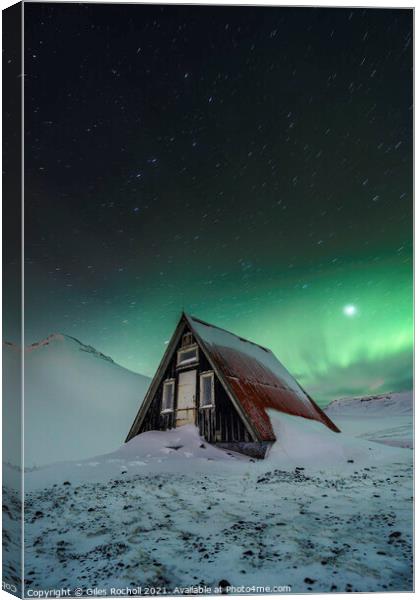 Snowy cabin and northern lights Canvas Print by Giles Rocholl