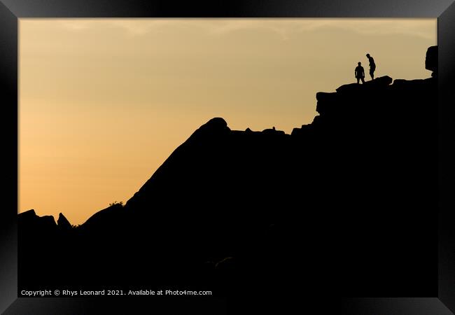Two rock climbers look back from the summit of stanage edge in england Framed Print by Rhys Leonard