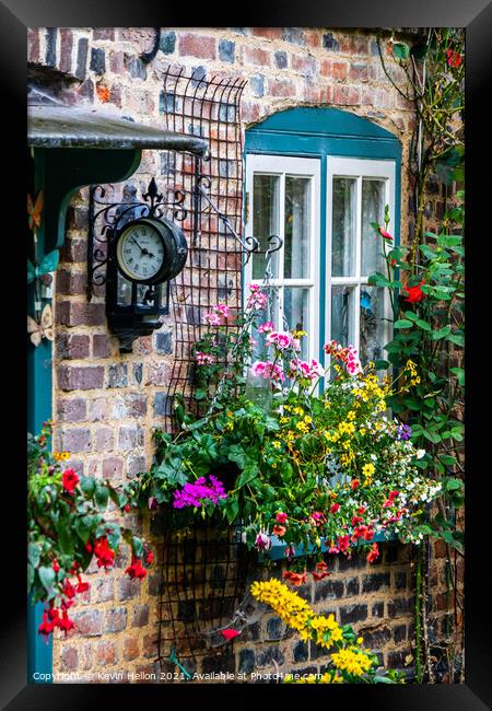 Flowers and a clock outside an English country cottage  Framed Print by Kevin Hellon