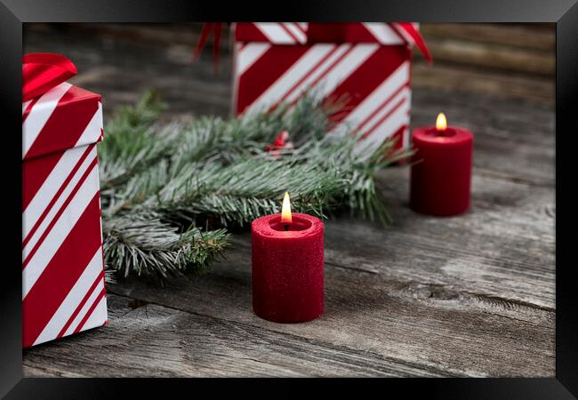 Burning red candle with decorations in background for a merry Ch Framed Print by Thomas Baker