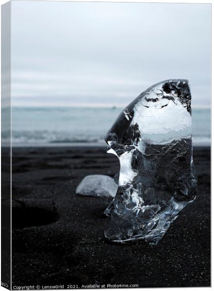 Clear piece of glacial ice on black sand Canvas Print by Lensw0rld 