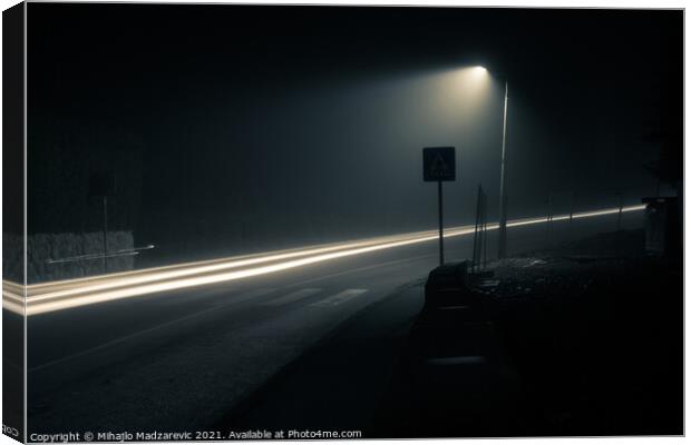 Dark foggy city street at night with a light trail Canvas Print by Mihajlo Madzarevic
