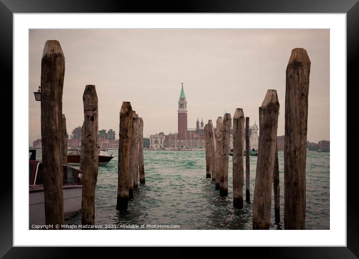 Wooden pillars at Venice bay symmetrically aligned pointing at Italian buildings in the back  Framed Mounted Print by Mihajlo Madzarevic