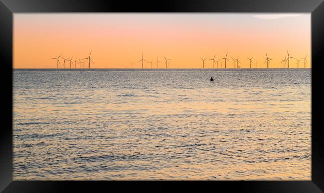 Iron Man watches the sunset at high tide Framed Print by Jason Wells