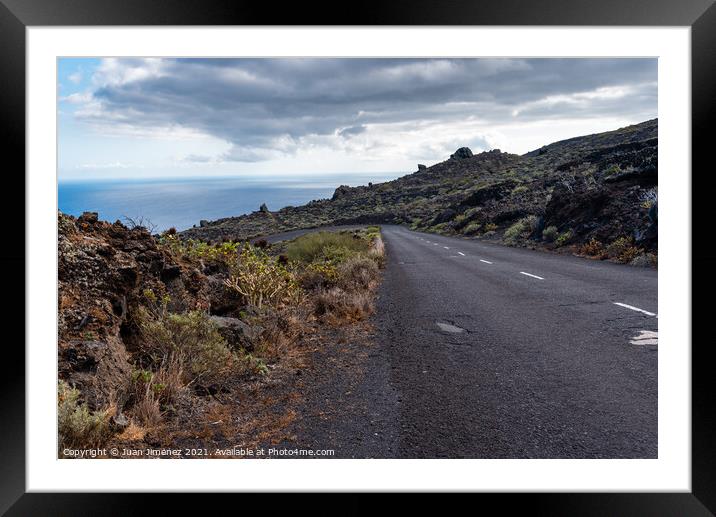 Empty road in a volcanic landscape in the Island of La Palma Framed Mounted Print by Juan Jimenez