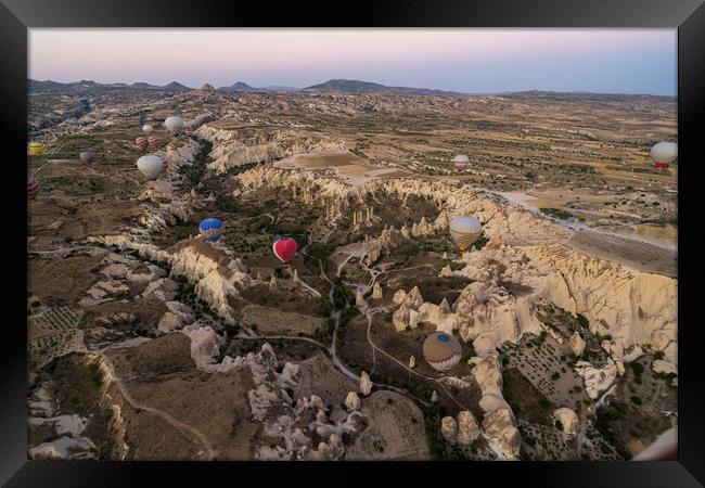 Many colorful hot air balloons flight above mountains and rocky formation - panorama of Cappadocia at sunrise. Wide landscape of Goreme valley - billboard background for your travel concept in Turkey Framed Print by Arpan Bhatia