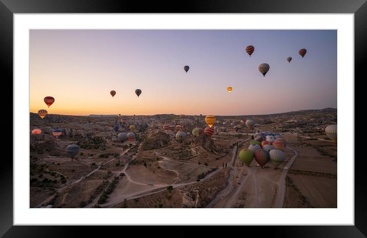 Cappadocia, Turkey - September 14, 2021: Wide angle aerial panoramic shot of colorful hot air balloons together floating in the sky at early morning sunrise horizon in Goreme national park Framed Mounted Print by Arpan Bhatia
