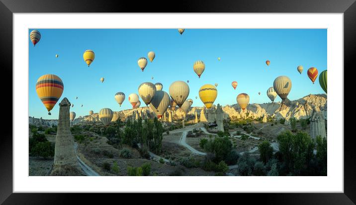 Panorama of bunch of colorful hot air balloon flying early morning in Cappadocia, Turkey against typical rock formation due to volcanic activity in love valley located in Goreme national park Framed Mounted Print by Arpan Bhatia